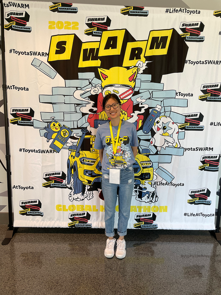 A participant at the Toyota hackathon event backdrop
