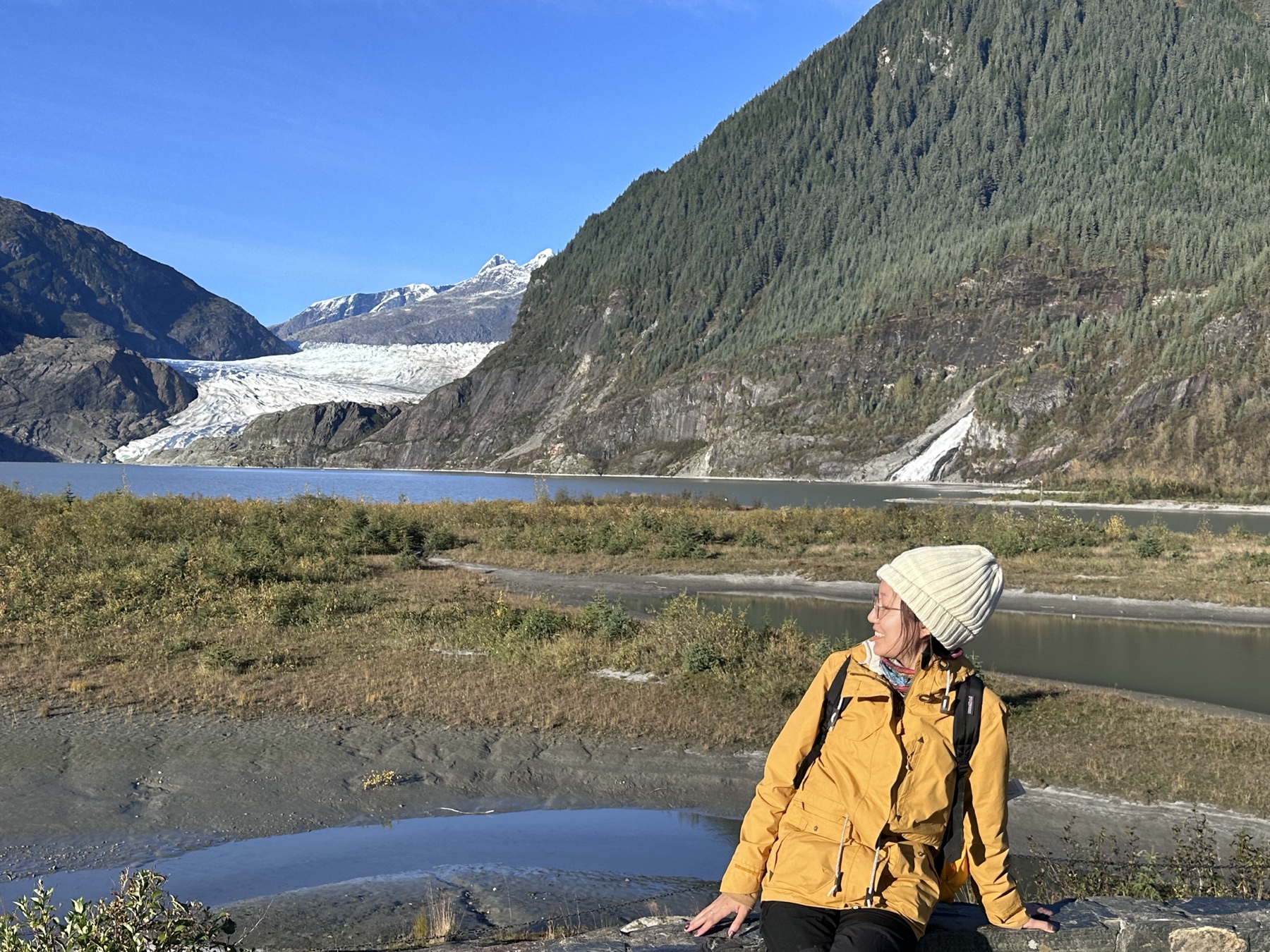 Keyan visiting a glacier in a yellow jacket