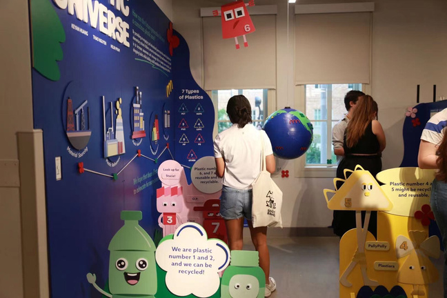 Visitors exploring the blue story wall and character panels during the exhibition opening