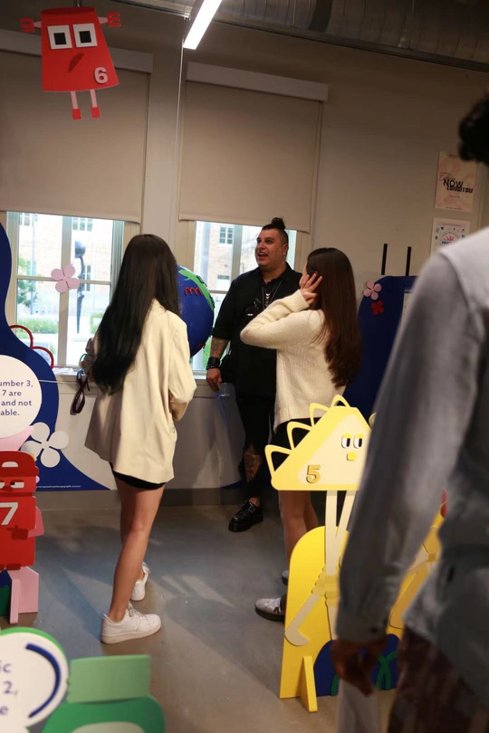 Opening-night visitors talking beside the Plastic Pals character displays